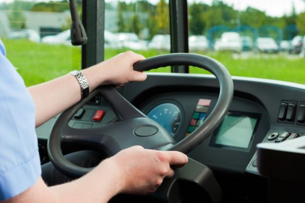 Bus driver hands on steering wheel