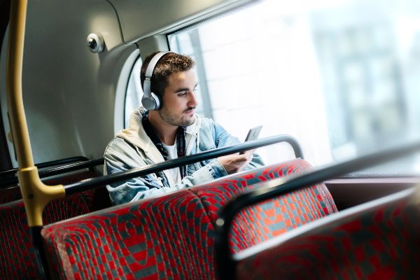 Caucasian man listens to music while traveling in an urban bus