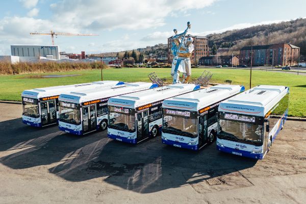 Image showing a row of 5 stationary buses in Glasgow which are operated by McGills Buses. The bus operator uses Omnibus solutions to optimise scheduling.